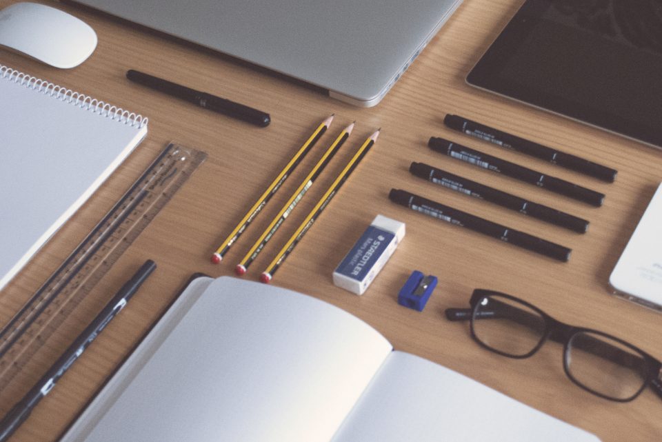 Bureau de dirigeant avec ordinateur portable et lunettes, entre deux tâches de prospection commerciale